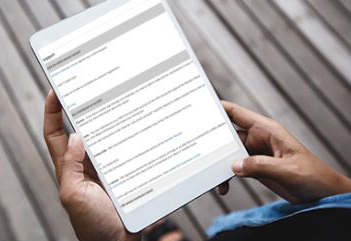 Male hands holding tablet with FAQs on screen