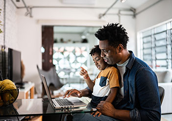 Father and son working on a laptop